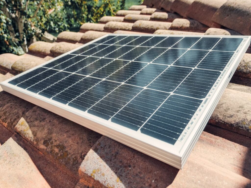 A worker installing a solar panels on a residential property.