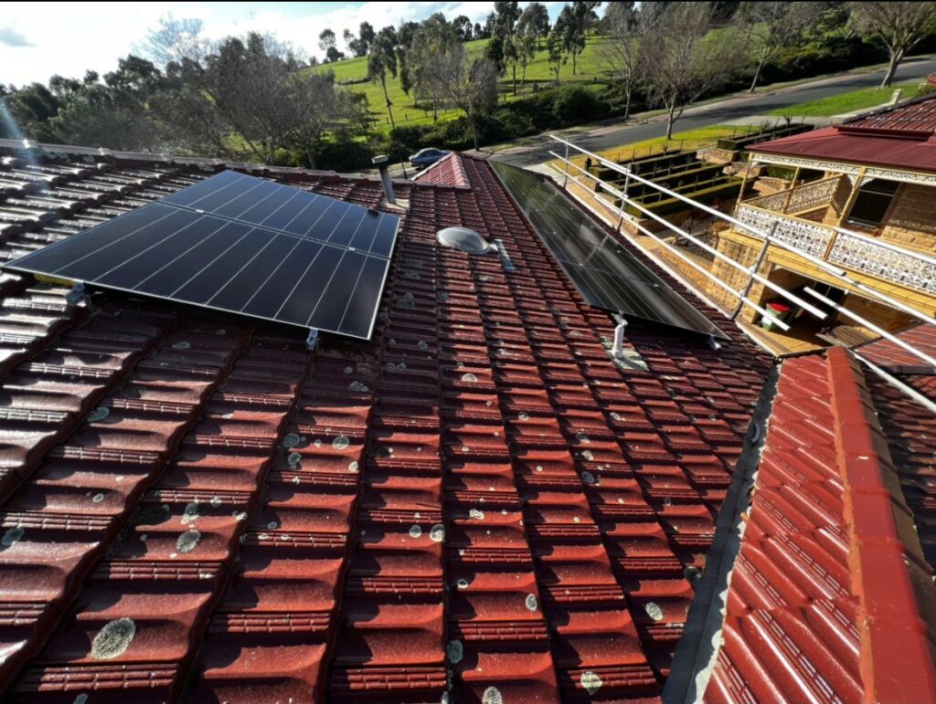 Suburban roof with solar panels on red tiles